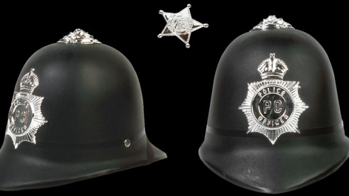 UK police office uses computer to look up ex police helmets